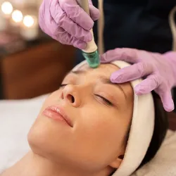 Esthetician performing dermaplaning facial treatment on client at Salon De Cheveux spa in Cañon City